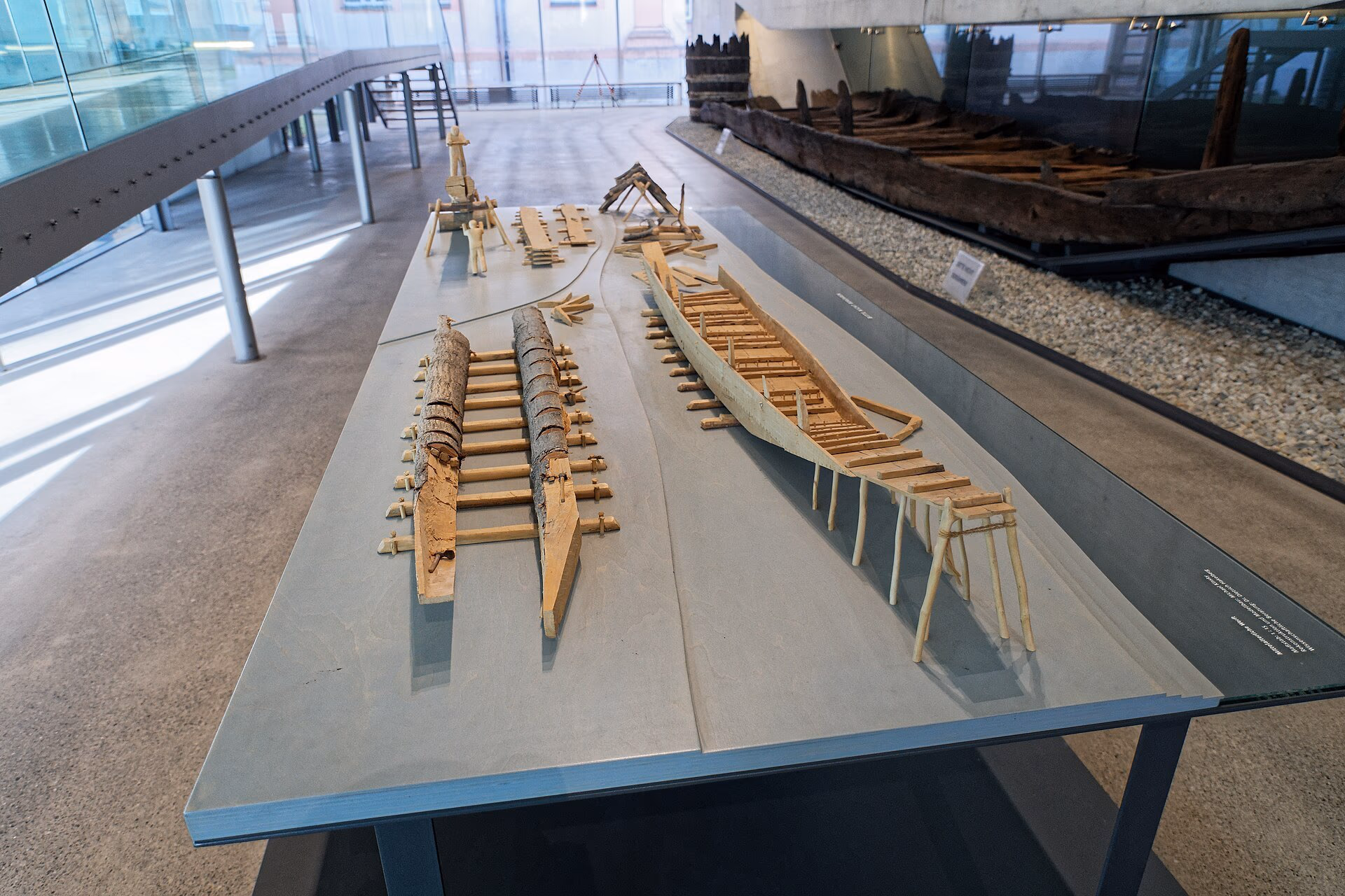 Ausstellung im Archäologischen Landesmuseum Konstanz mit Modellen historischer Boote, dahinter ein Einbaum