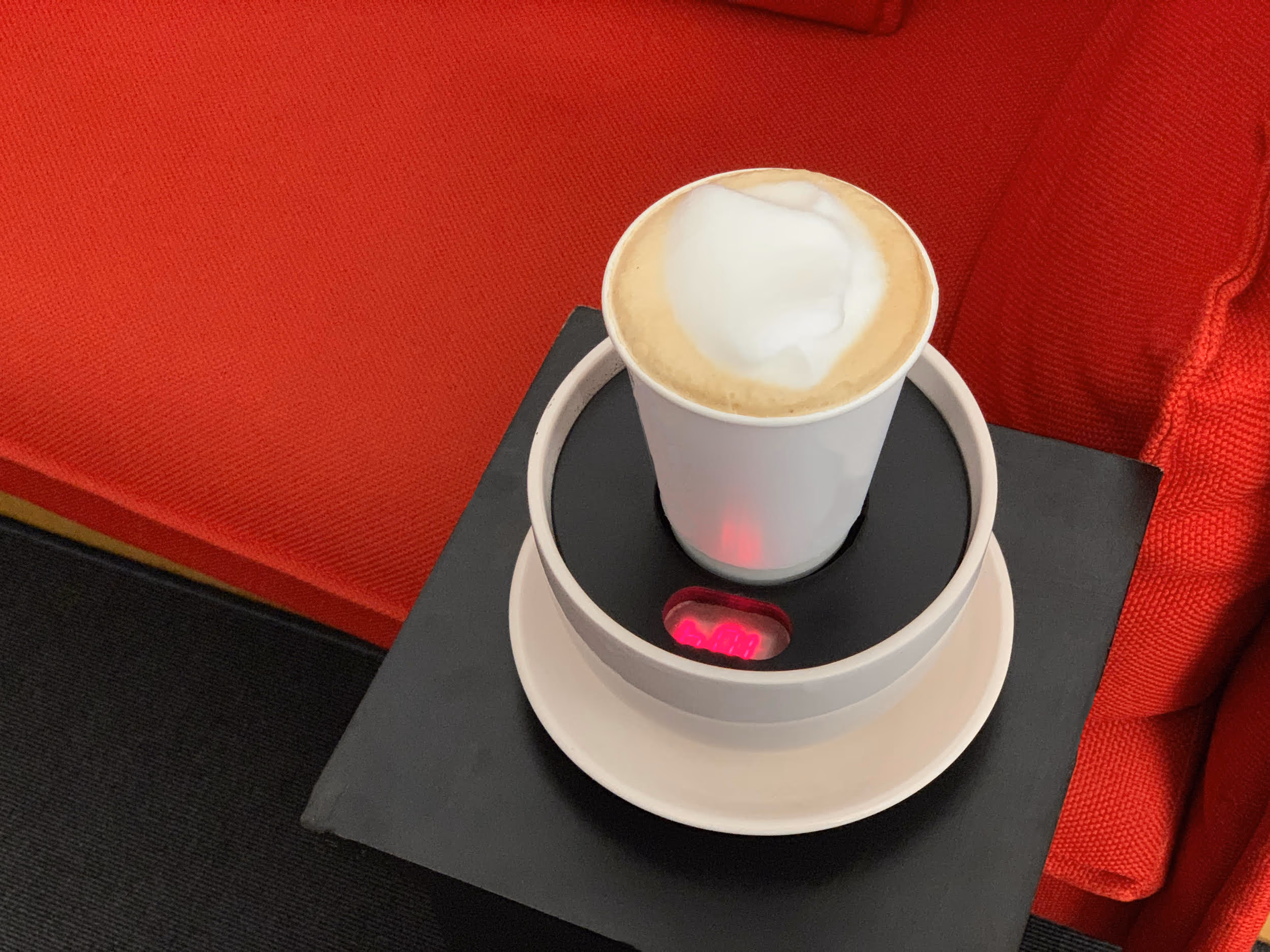 Der Geocache im Café Machwitz: ein Becher Cappuccino auf dem Thermosensor, dessen Anzeige rot aufleuchtet