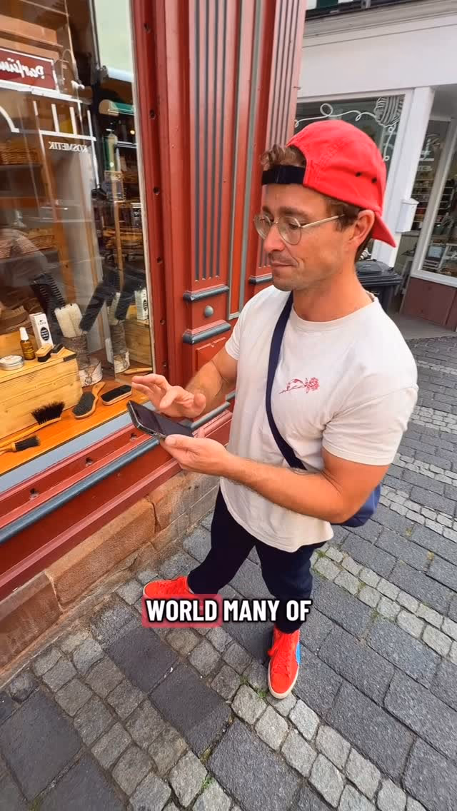 Der Geocaching Vlogger steht mit dem Smartphone vor einem Schaufenster in der Marburger Oberstadt