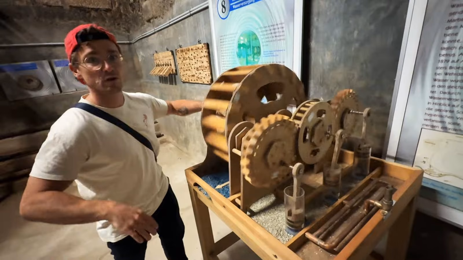 Daniel Pflieger im Gewölbekeller neben einer Rätselmaschine aus hölzernen Zahnrädern