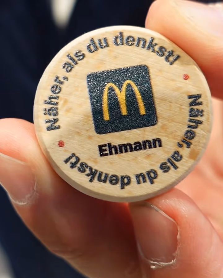 Die Holzmünze von McDonald’s Ehmann: „Näher, als du denkst!“