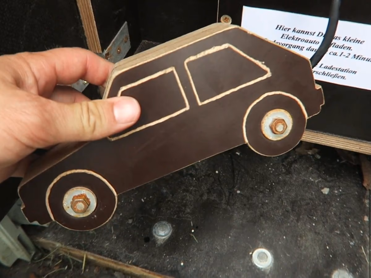 Ein Holzauto an der Ladestation: Diese Station spielt mit Elektromobilität