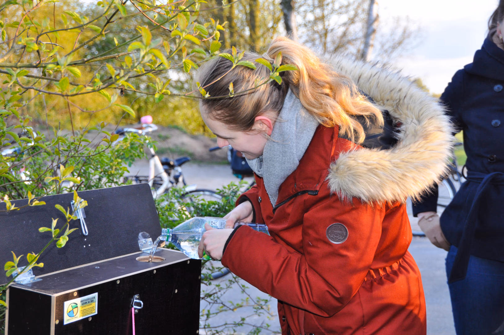 Ein Kind öffnet im Winter einen Geocache der Oldenburger Klimaschätze-Tour