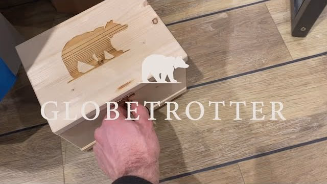 Vorschaubild des Videos „Globetrotter Geocaching“: eine Holzkiste mit dem Globetrotter-Bären